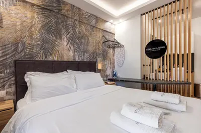 a bedroom with a white bed with towels on it at Stylish Living-Ariadne in Athens