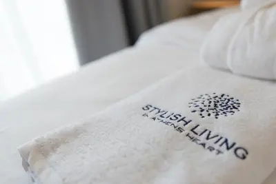a towel on a bed with the words wish living on it at Stylish Living-Ariadne in Athens