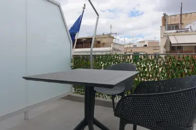 a table and two chairs on a balcony at Stylish Living-Ariadne in Athens