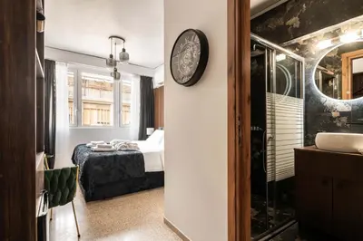 a bedroom with a bed and a clock on a wall at Dema Luxury Suites - Perikleous E4 in Athens