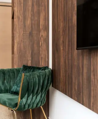 a green leather chair sitting next to a television at Dema Luxury Suites - Perikleous E4 in Athens