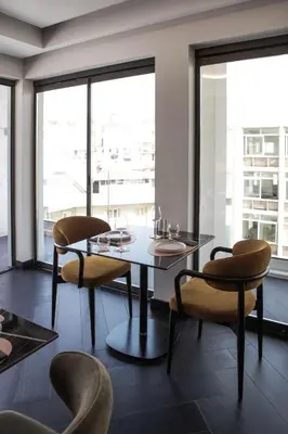 a dining room with a table and chairs and windows at Luwian Athens Boutique Hotel in Athens