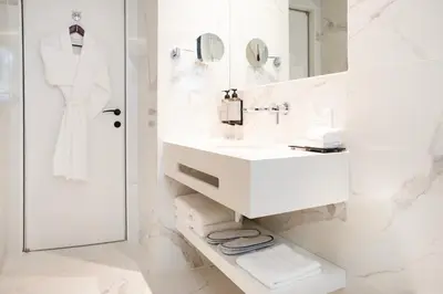 a white bathroom with a sink and a mirror at Luwian Athens Boutique Hotel in Athens