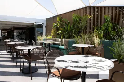 an outdoor patio with tables and chairs and plants at Luwian Athens Boutique Hotel in Athens