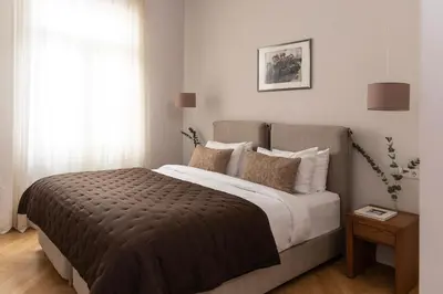 a bedroom with a large bed and a window at Kolonaki Chic Haven - A Downtown Retreat in Athens