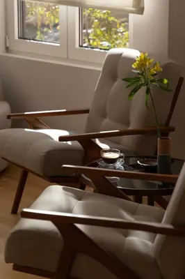 a living room with two chairs and a table with a plant at Kolonaki Chic Haven - A Downtown Retreat in Athens