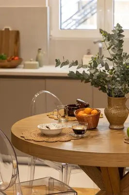 a wooden table with bowls of fruit on it in a kitchen at Kolonaki Chic Haven - A Downtown Retreat in Athens