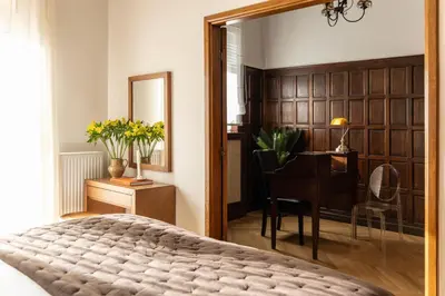 a bedroom with a bed and a desk and a mirror at Kolonaki Chic Haven - A Downtown Retreat in Athens