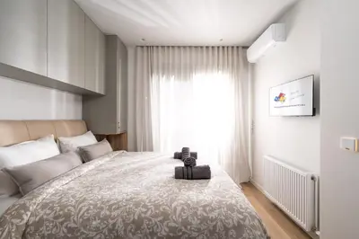 a bedroom with a large bed and a window at Alkis Luxury By Greece Apartments in Athens