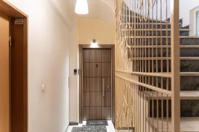 a hallway with a wooden door and a staircase at Alkis Luxury By Greece Apartments in Athens