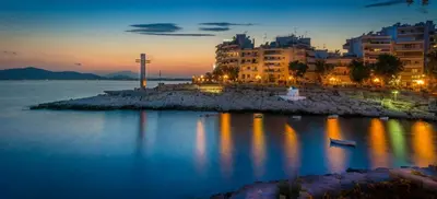 a city with a cross in the water at night at Apartment with terrace in Piraiki in Piraeus