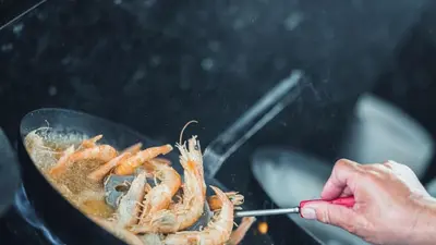 a person is cooking shrimp in a pan at Apartment with terrace in Piraiki in Piraeus