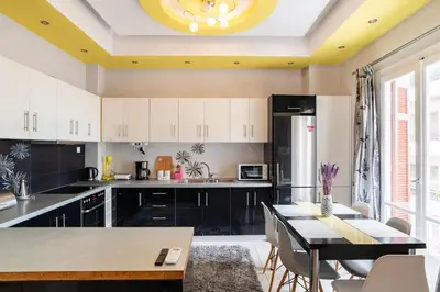 a kitchen with white cabinets and a dining table at Apartment with terrace in Piraiki in Piraeus