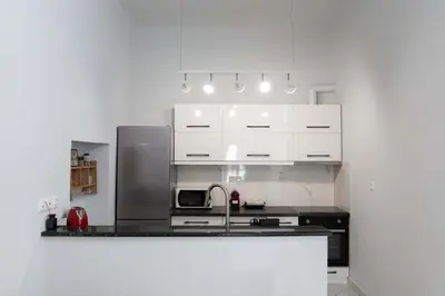 a kitchen with white cabinets and a sink at Private Spacious Apartment in Athens