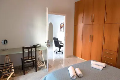 a bedroom with a bed and a desk and a mirror at Private Spacious Apartment in Athens