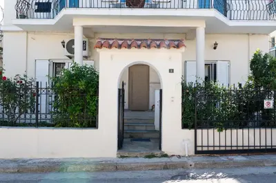 a white house with a gate and stairs at Private Spacious Apartment in Athens