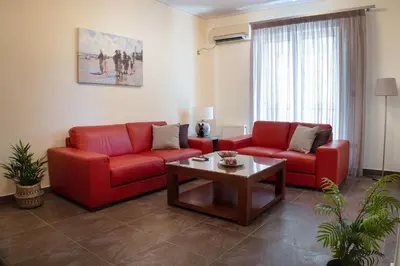 a living room with two red couches and a coffee table at Cozy flat in Elliniko - 300Mbps Wi-Fi in Athens