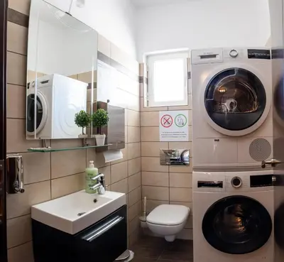 a bathroom with a washing machine and a washer at Cozy flat in Elliniko - 300Mbps Wi-Fi in Athens