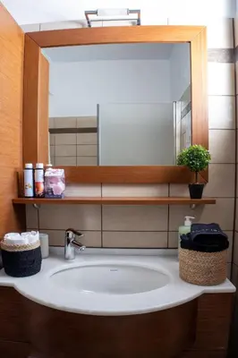 a bathroom sink with a large mirror above it at Cozy flat in Elliniko - 300Mbps Wi-Fi in Athens