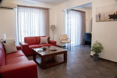 a living room with a red couch and a coffee table at Cozy flat in Elliniko - 300Mbps Wi-Fi in Athens