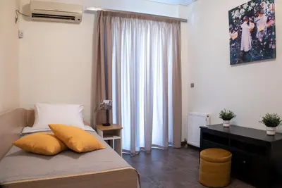 a bedroom with a bed with yellow pillows on it at Cozy flat in Elliniko - 300Mbps Wi-Fi in Athens