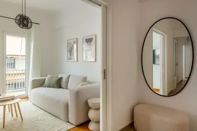 a living room with a couch and a mirror at Sunny 2BR Apartment in Nea Smyrni by UPSTREET in Athens
