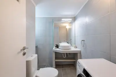 a bathroom with a toilet and a sink at Sunny 2BR Apartment in Nea Smyrni by UPSTREET in Athens
