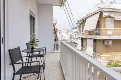 a balcony with two chairs and a table at Sunny 2BR Apartment in Nea Smyrni by UPSTREET in Athens