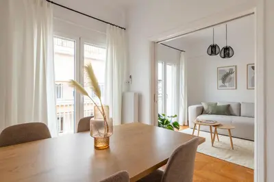 a living room with a wooden table and a couch at Sunny 2BR Apartment in Nea Smyrni by UPSTREET in Athens