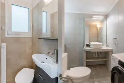 a bathroom with a sink and a toilet and a mirror at Sunny 2BR Apartment in Nea Smyrni by UPSTREET in Athens