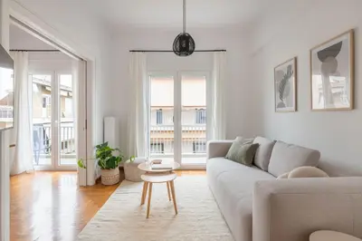 a white living room with a couch and a table at Sunny 2BR Apartment in Nea Smyrni by UPSTREET in Athens