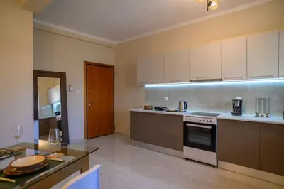 a kitchen with white cabinets and a stove top oven at Luxury Modern 2 bed Elegance in Athens