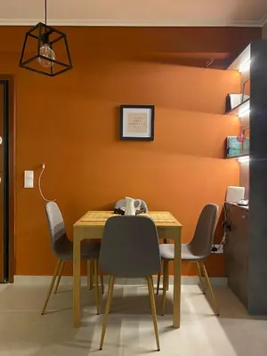 a table and chairs in a room with an orange wall at Miliannas in Athens