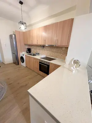 a kitchen with wooden cabinets and a white counter top at Check Point - Athens Heart in Athens
