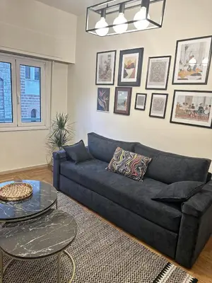 a living room with a black couch and a table at Check Point - Athens Heart in Athens