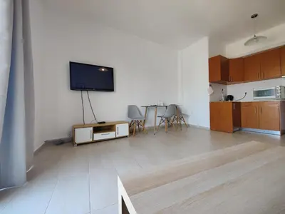 a living room with a flat screen tv on a wall at Finikas Spata Holiday Apartment in Spáta