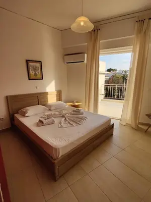 a bedroom with a bed and a large window at Finikas Spata Holiday Apartment in Spáta