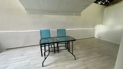 two chairs and a table in an empty room at Luxury Semi Basement Apartment with Terrace in Athens