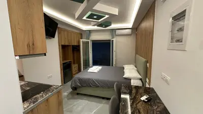 a small room with a bed and a kitchen at Luxury Semi Basement Apartment with Terrace in Athens