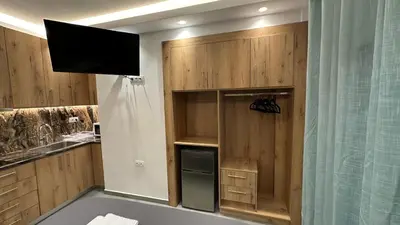 a kitchen with wooden cabinets and a television in it at Luxury Semi Basement Apartment with Terrace in Athens