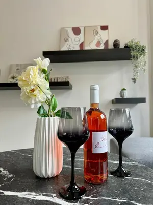 a bottle of wine and two glasses on a table at Kozy Koala Apartments n22 in Athens