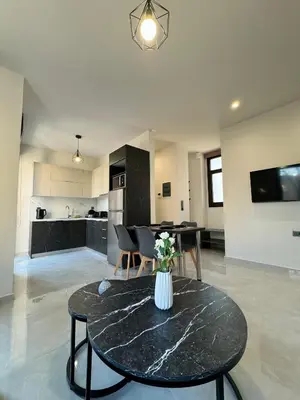 a living room with a table and a kitchen at Kozy Koala Apartments n22 in Athens