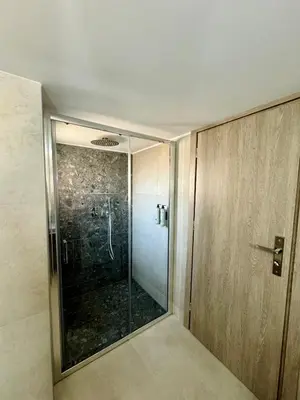 a bathroom with a shower with a glass door at Kozy Koala Apartments n22 in Athens