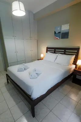 a bedroom with a large white bed with towels on it at Olive House close to Acropolis in Athens