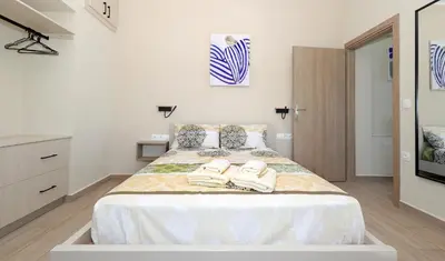 a bedroom with a large bed with towels on it at Niko's Beach Suites No1 in Agia Marina Aegina