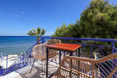 a table and chairs on a balcony overlooking the ocean at Niko's Beach Suites Νο2 in Agia Marina Aegina