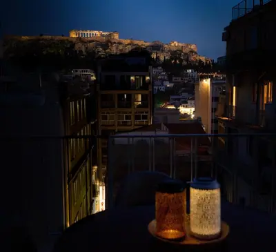 a view of a city at night from a balcony at Parthenon View Apartment in Athens