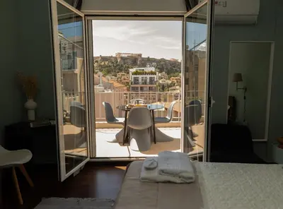 a bedroom with a view of a table and chairs at Parthenon View Apartment in Athens