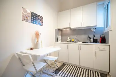 a kitchen with white cabinets and a table and chairs at kato patisia cozy apartment for 2 persons by MPS in Athens