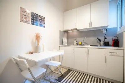 a kitchen with white cabinets and a table and chairs at kato patisia cozy apartment for 2 persons by MPS in Athens